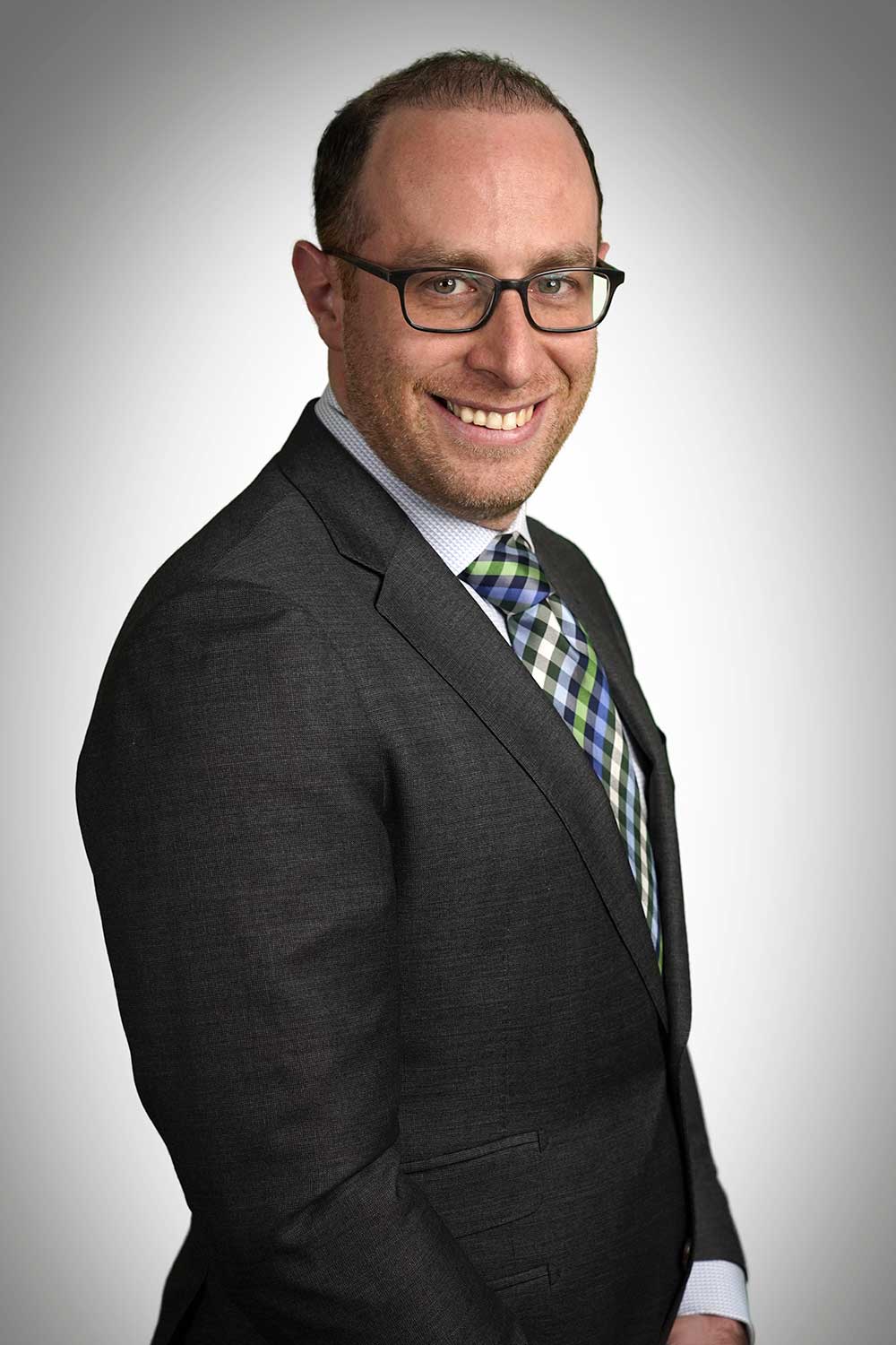 Headshot of neurosurgeon Joshua Marcus wearing a suit and smiling.