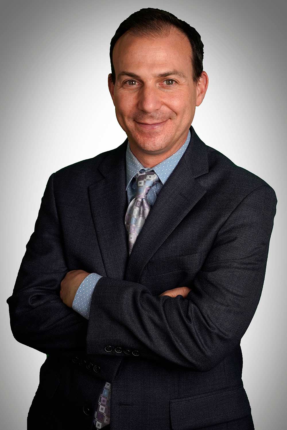 Headshot of chief neurosurgeon Scott Anderson wearing a suit and smiling.