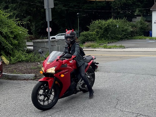 NH Spine Patient Carolina Herrera riding a red motorcycle wearing all black